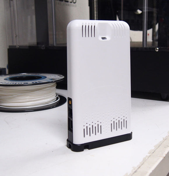 White EnviroMonitor IP Gateway by Davis Instruments with ventilation slots, standing on a white surface.