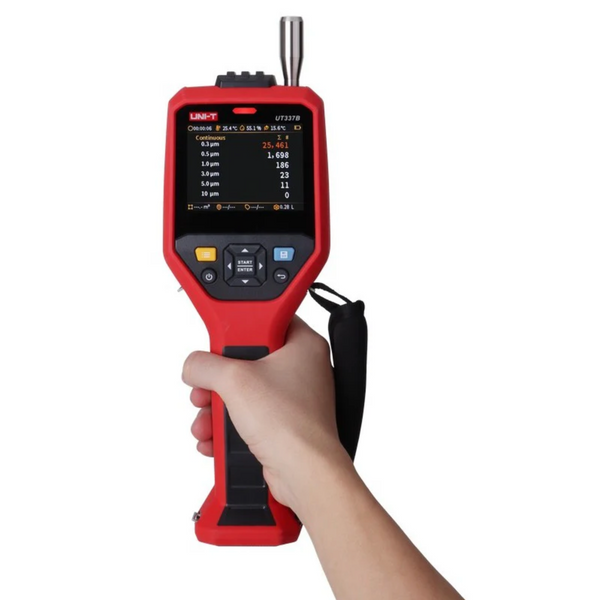 Red laser particle counter by Uni-Trend being held in a hand, displaying environmental particulate readings on a digital screen.

